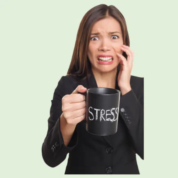 Stressed looking woman wearing a black pantsuit holding a coffee mug with stress written on it.