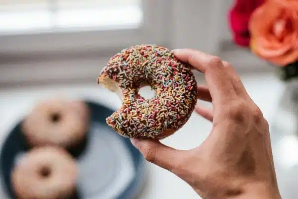 Donut with chocolate frosting and rainbow sprinkles.