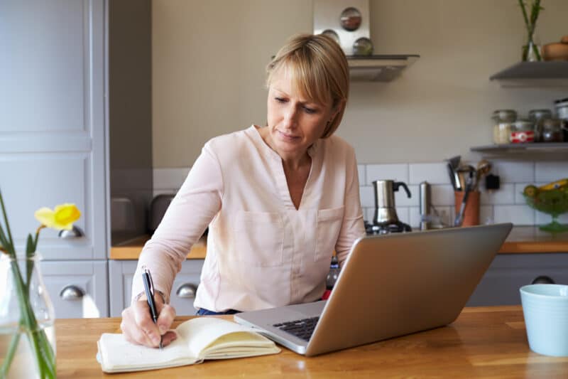 Woman working from home on laptop in modern apartment.