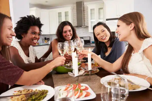 lose weight without feeling hungry - group of female friends enjoying a dinner party